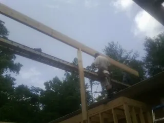 Carpenter setting a ridge beam over a new addition frame — Ice Dam Removal by Roofing Brothers in Orrick