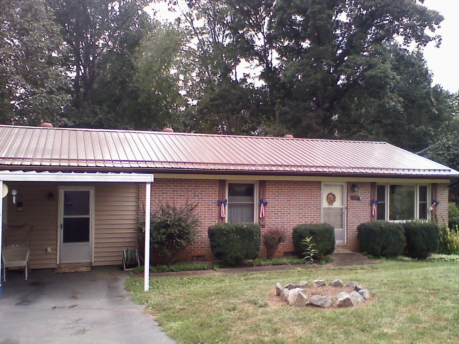 Bronze metal roof and carport on a brick ranch home — Roof Repair work by our crew in Orrick