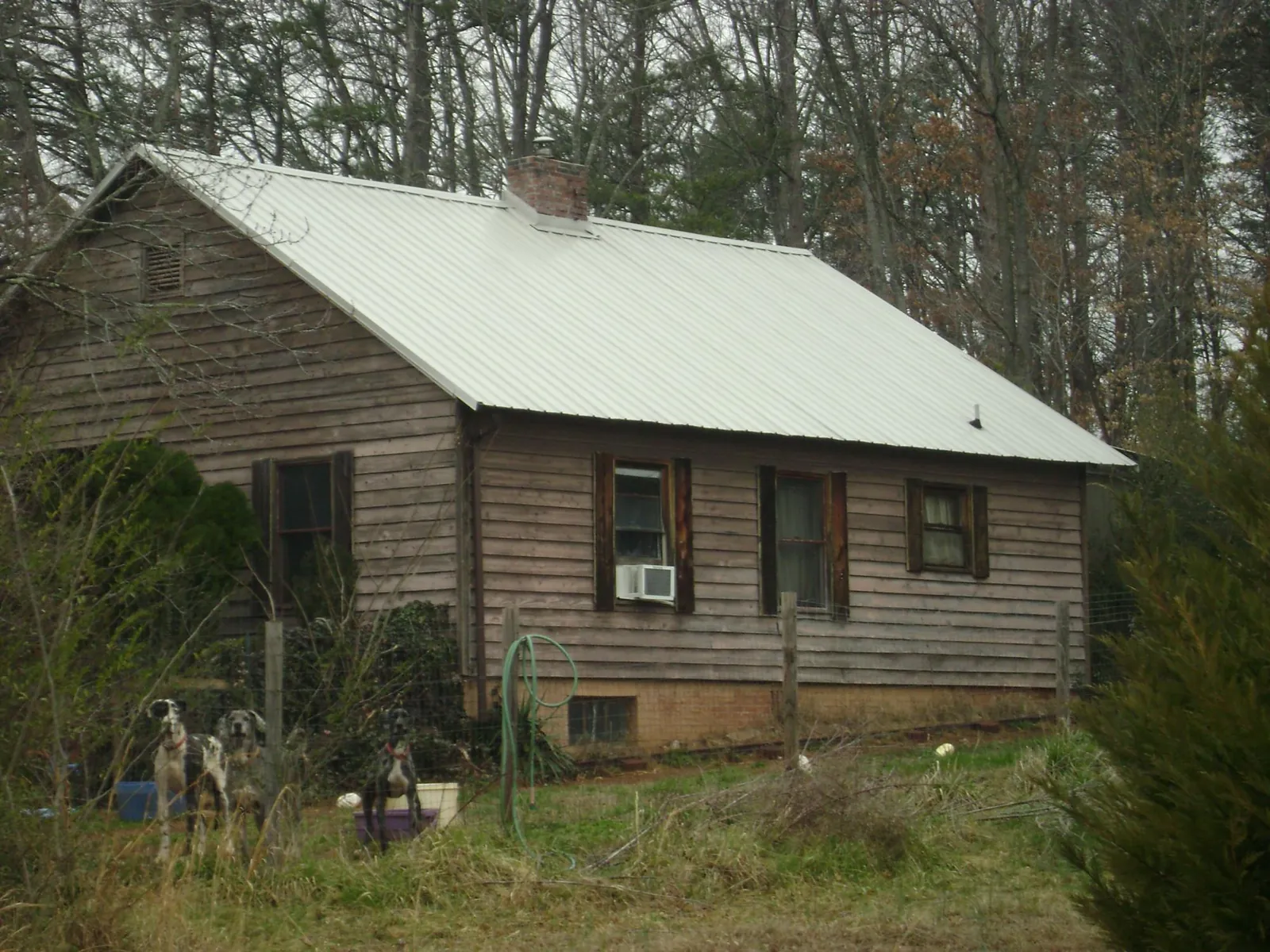 White metal roof on an old wood sided farmhouse, from a Metal Roof Installation job in Orrick
